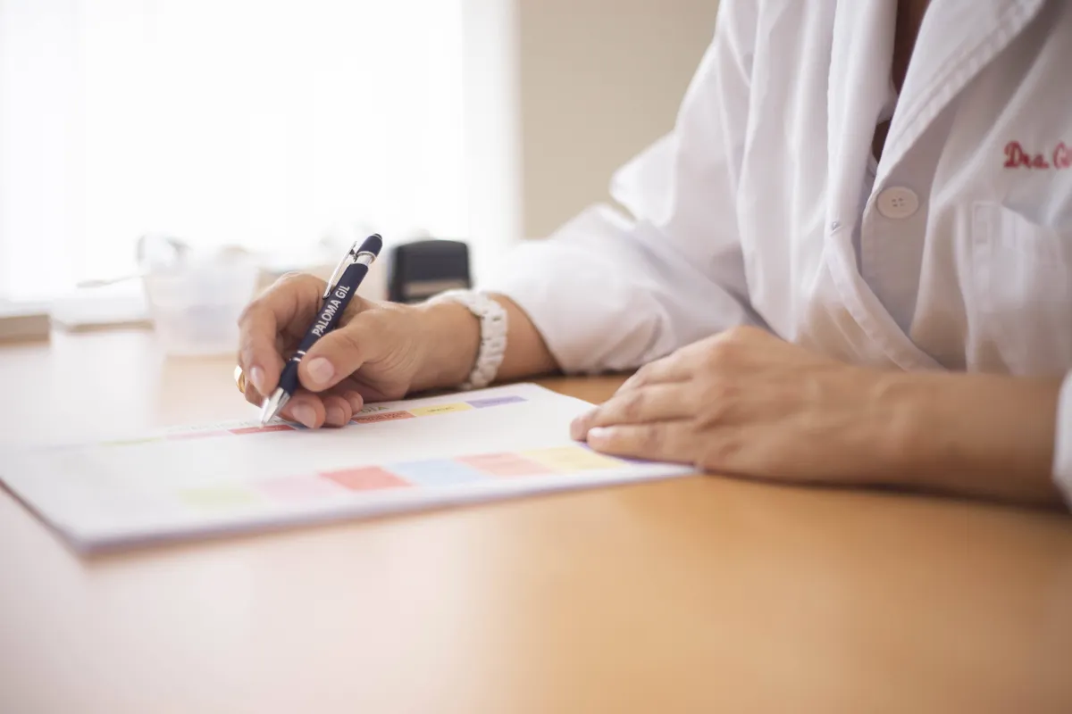 A healthcare professional completing a medical form at a desk.