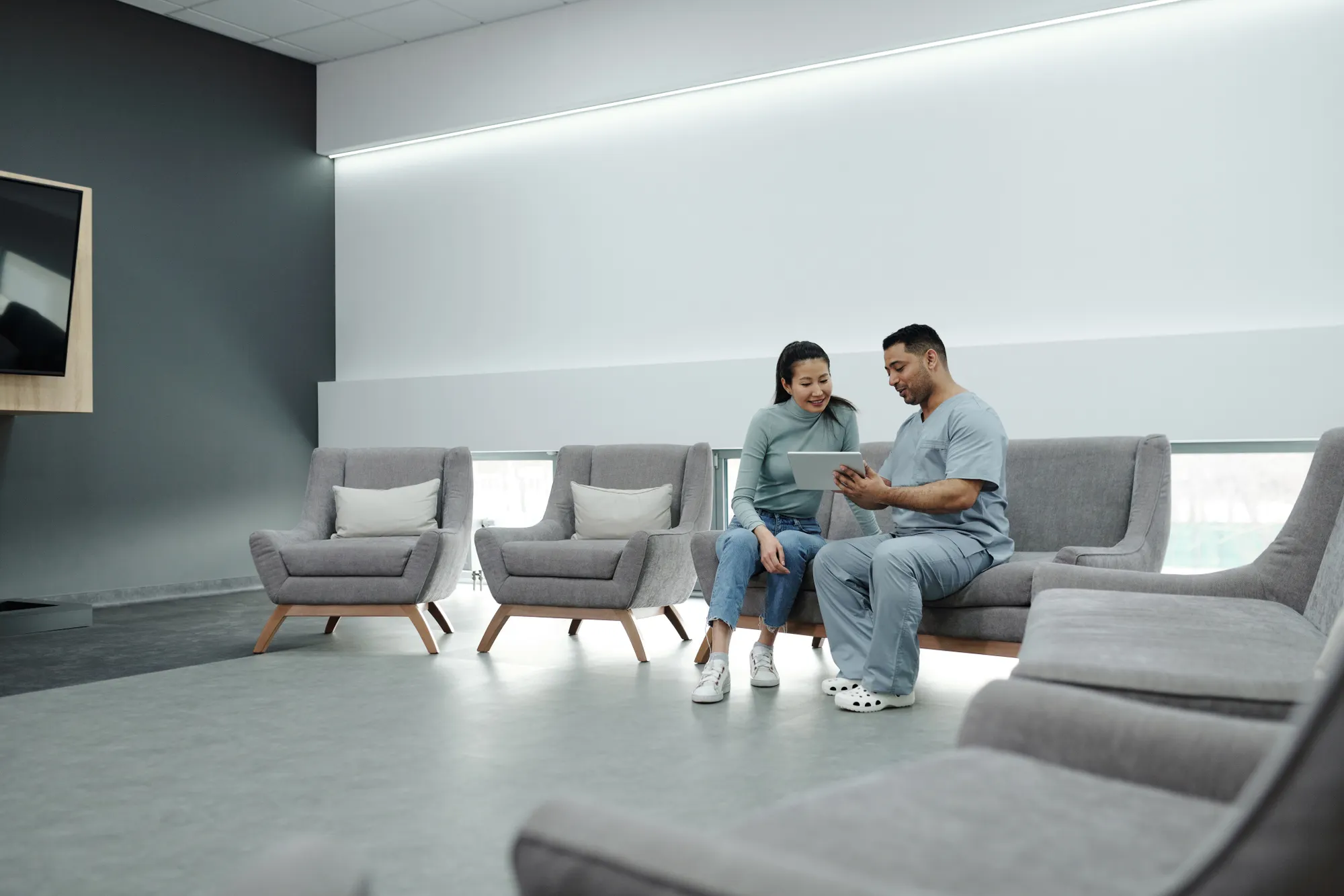 Two people talking in a bright practice waiting area.