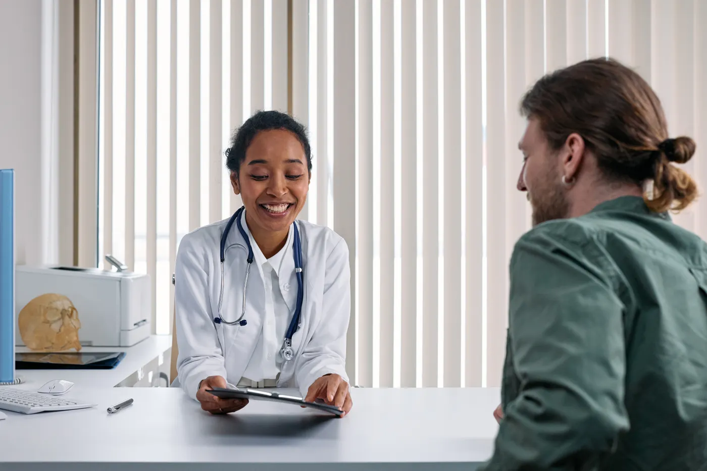A healthcare professional speaking with a patient during a consultation.