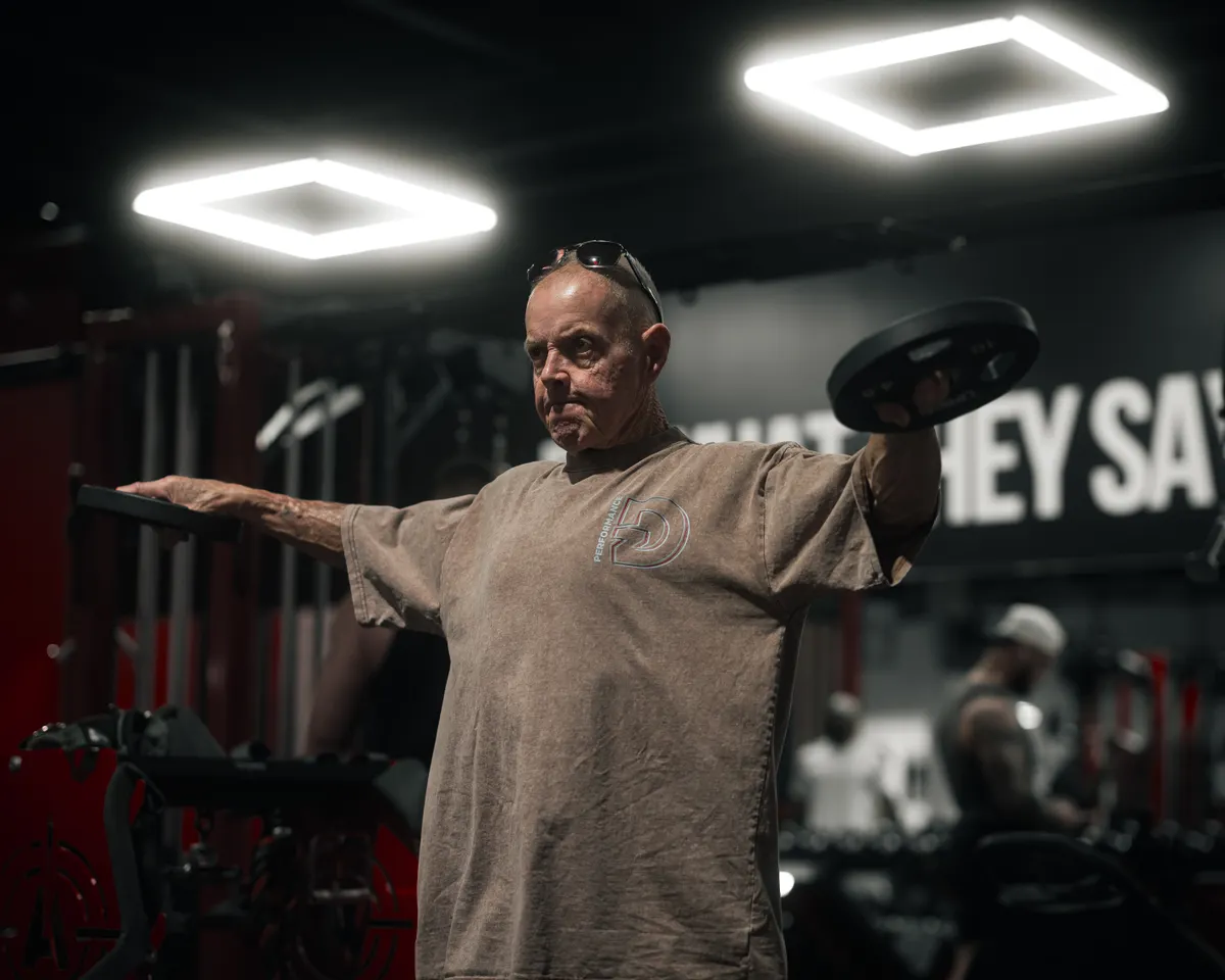 A man lifting a weight plate during a strength session.
