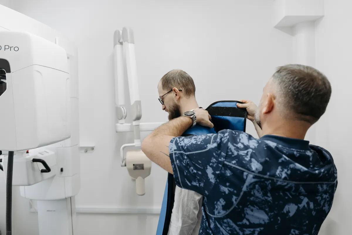 A radiographer positioning a patient at an x-ray unit.